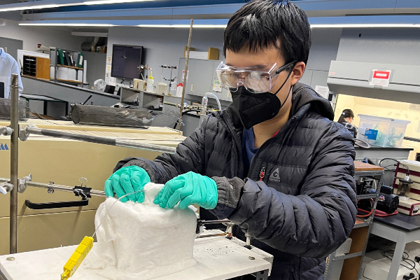 Student wearing mask works with nuclear cladding material in lab