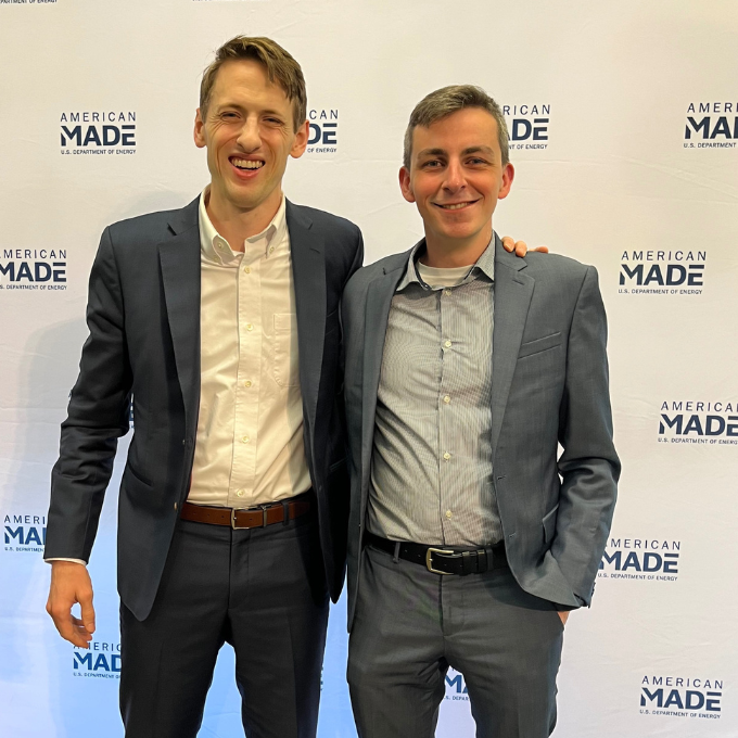 Two students stand in front of backdrop