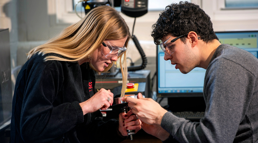 students looking at device in lab