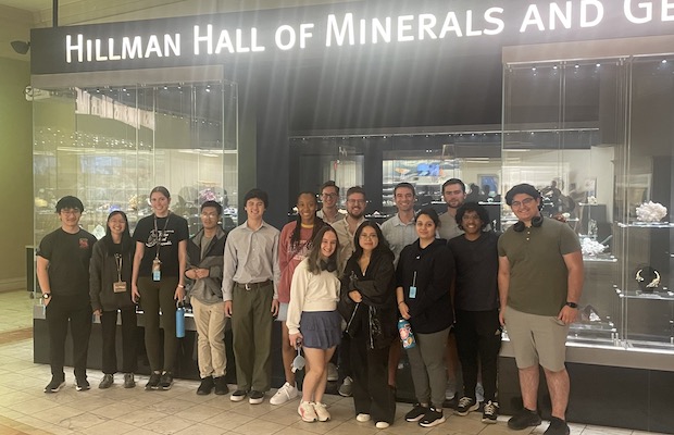 Students stand in front of hall of minerals and gems sign