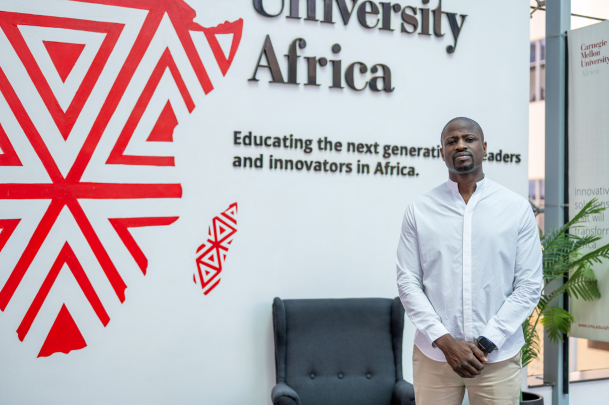 Dabo standing in front of CMU Africa sign