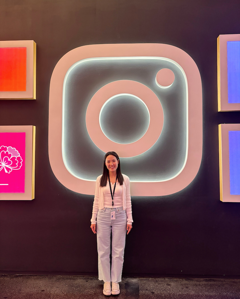 Ruby Jiang standing in front of Instagram logo neon sign