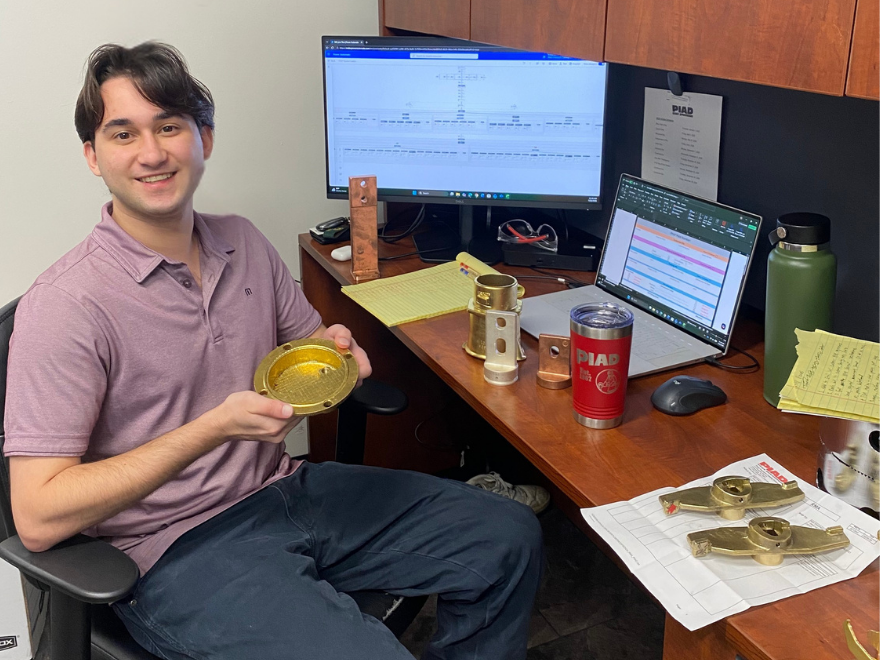 Person sitting at desk holding gold disk shaped object