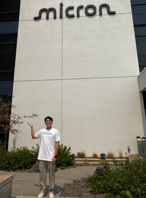 Person standing next to Micron sign